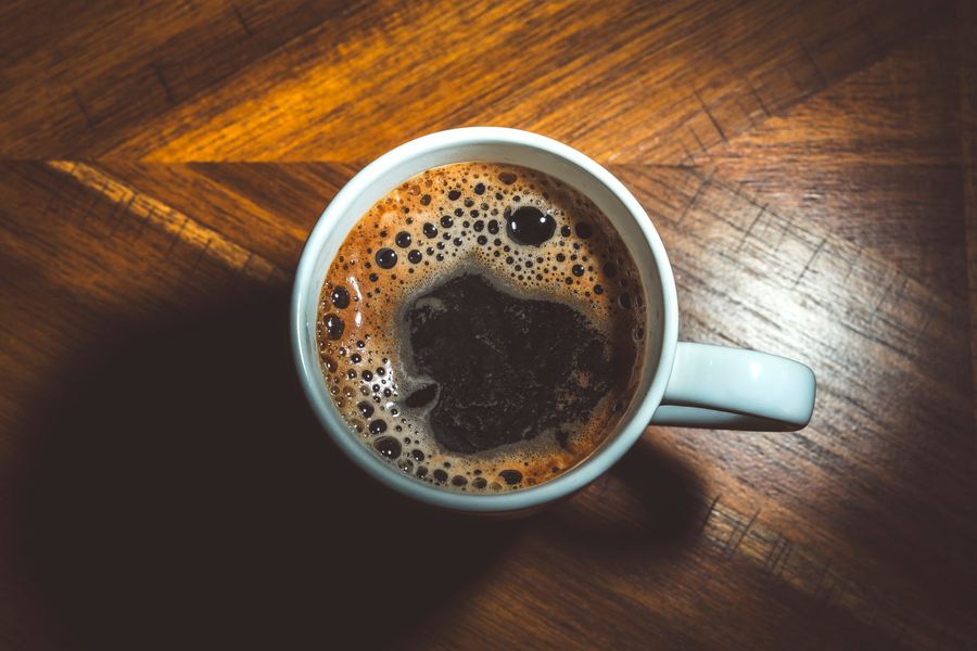 Taza de café sobre una mesa de madera