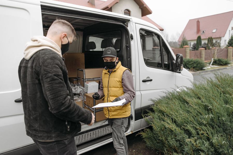 Repartidor entregando cajas desde una furgoneta